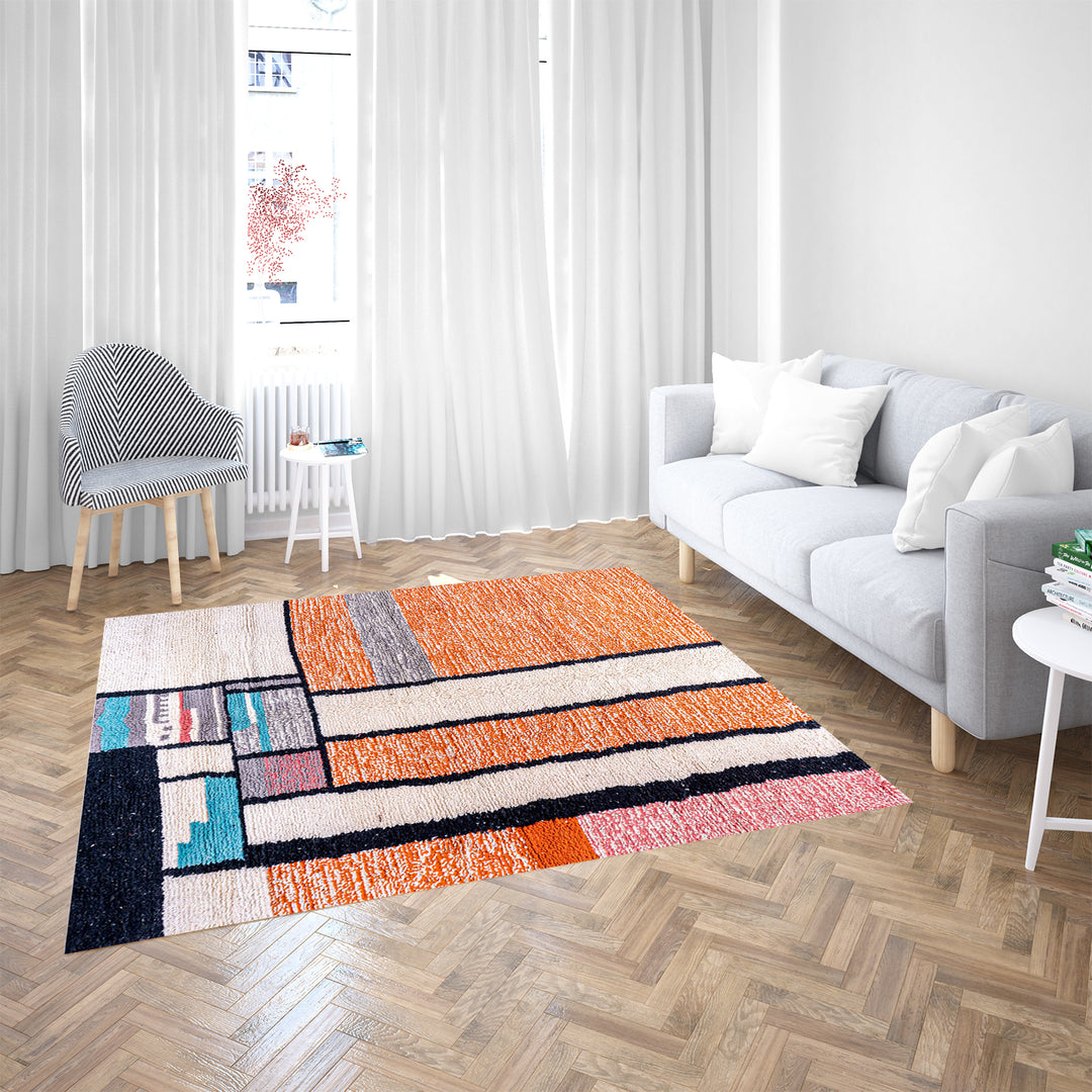 Colorful Moroccan rug with orange base and geometric wool patterns in black, cream, turquoise, and pink