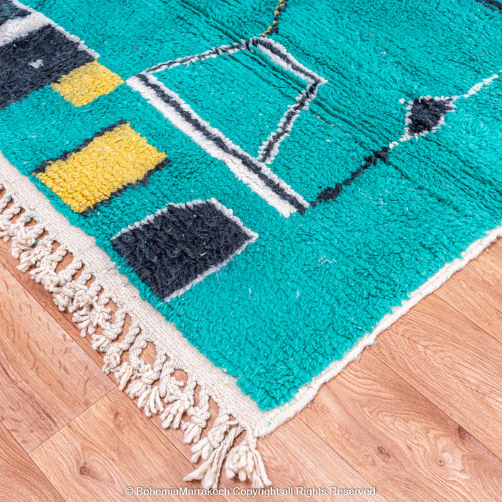 Handmade green Moroccan rug with bright diamond line patterns on deep green background