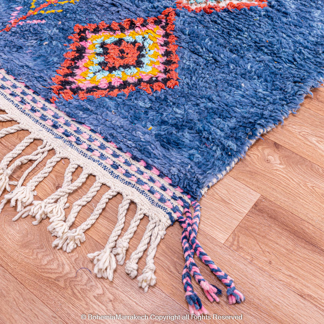 Colorful handmade blue Moroccan rug with diamond tribal designs on plush wool