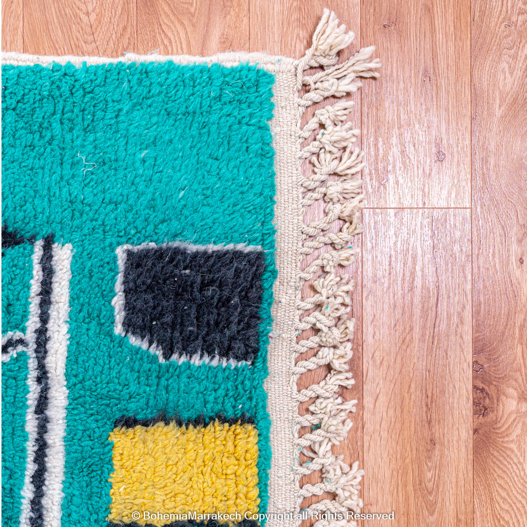Handmade green Moroccan rug with bright diamond line patterns on deep green background