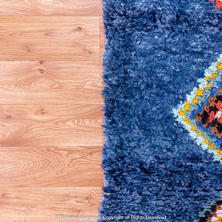 Colorful handmade blue Moroccan rug with diamond tribal designs on plush wool