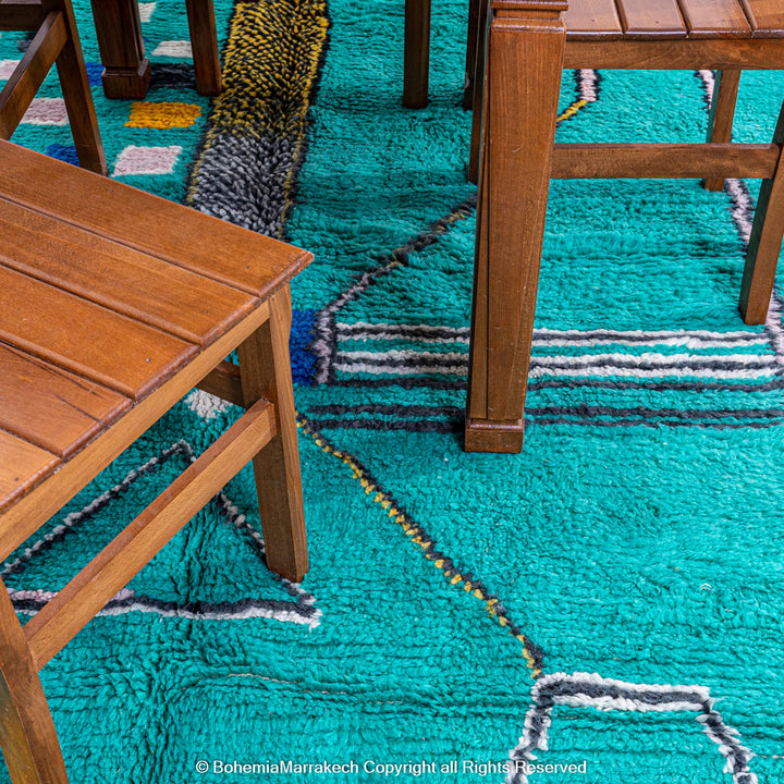 Handmade green Moroccan rug with bright diamond line patterns on deep green background