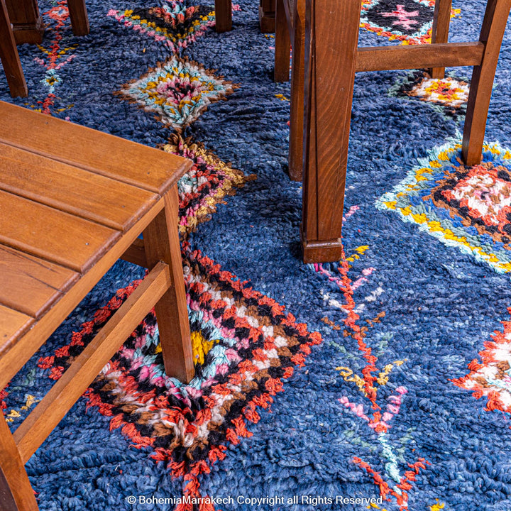 Colorful handmade blue Moroccan rug with diamond tribal designs on plush wool