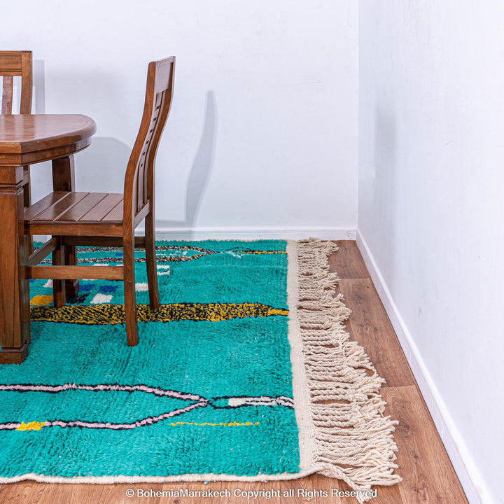 Handmade green Moroccan rug with bright diamond line patterns on deep green background