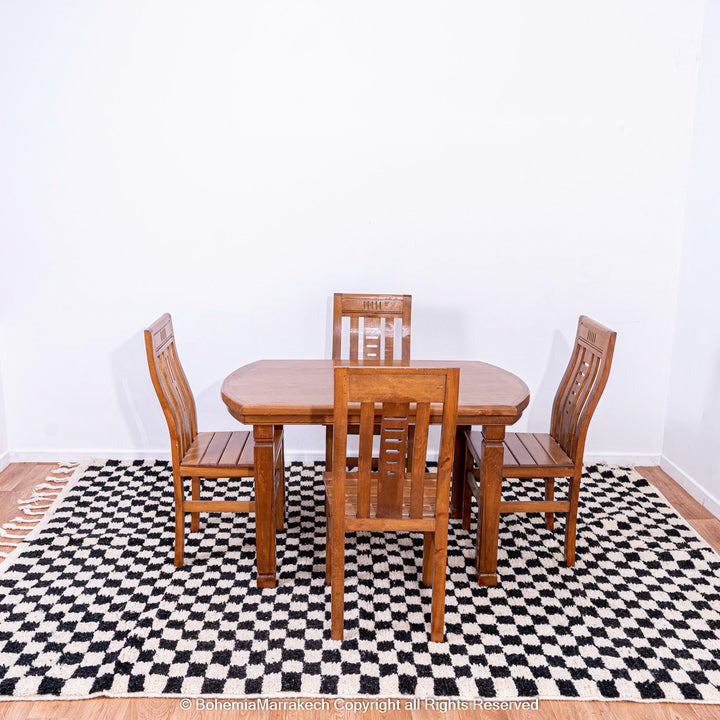 Black and white checkered Moroccan rug under wooden dining set