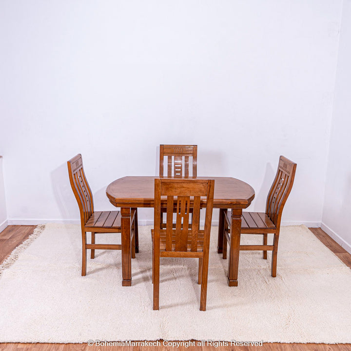 Plain white Moroccan wool rug under wooden dining table and chairs