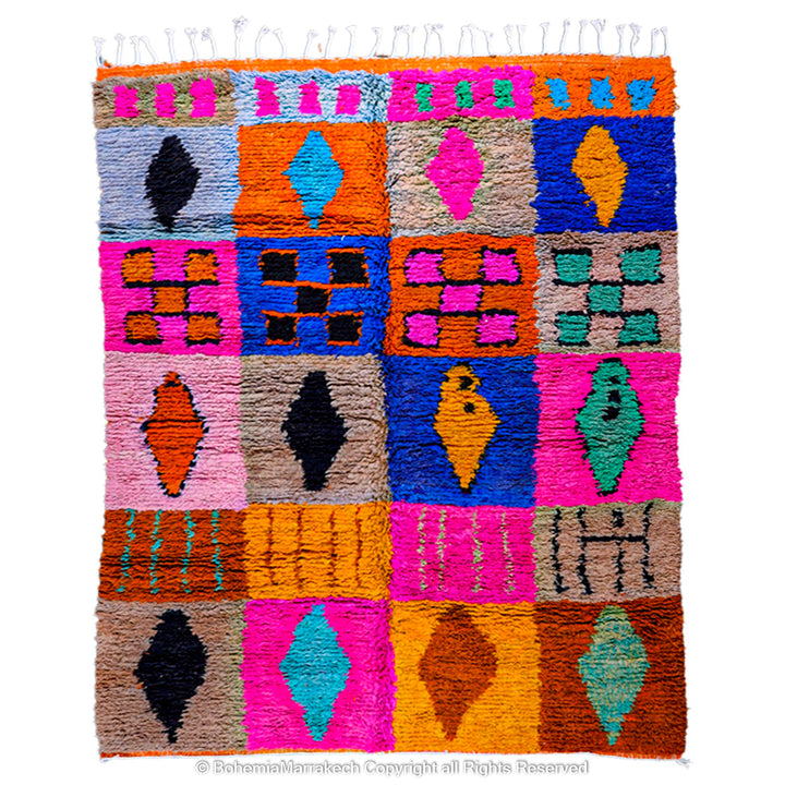 Colorful Moroccan wool rug with geometric blocks in pink, blue, orange. Handwoven Berber tribal motifs, perfect for bohemian decor.