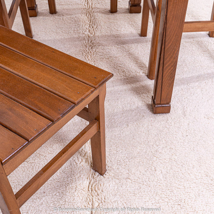 Plain White Moroccan Rug under wooden furniture in dining area, showcasing minimalist style and natural wool texture.