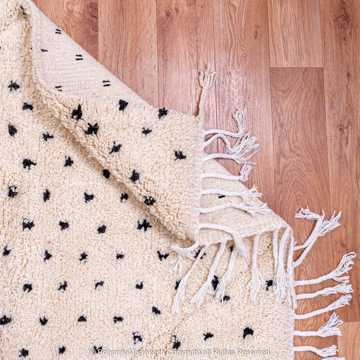 White Moroccan rug with black dots, handmade Beni Ourain wool carpet, ideal for modern interiors and cozy living spaces.