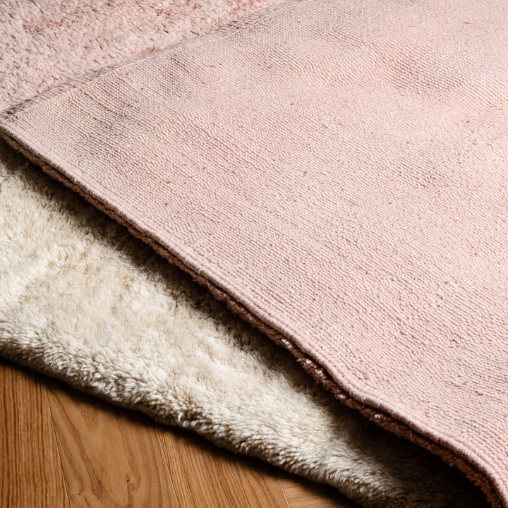 Custom Moroccan rug in blush pink and cream wool, showcasing texture and artisanal details. Perfect for modern interiors.