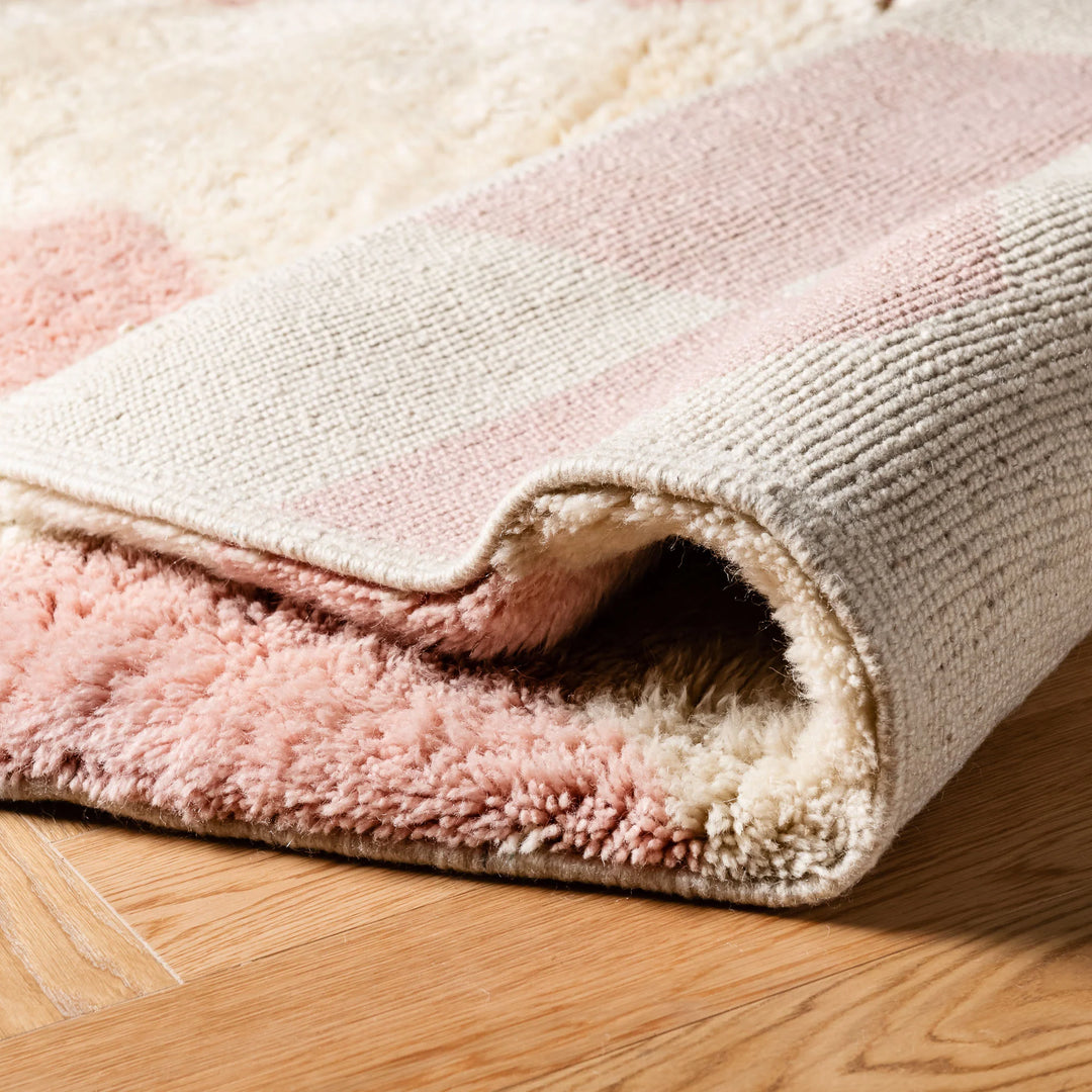 Close-up of a soft pink geometric Moroccan wool rug, showcasing plush texture and handcrafted design.