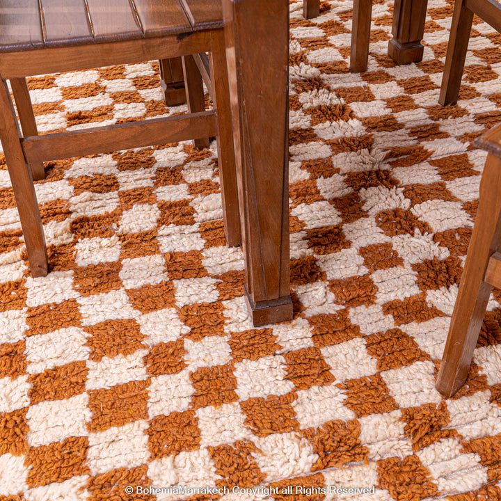 Handcrafted yellow and white checkered Moroccan rug under wooden dining table, made from 100% natural wool.