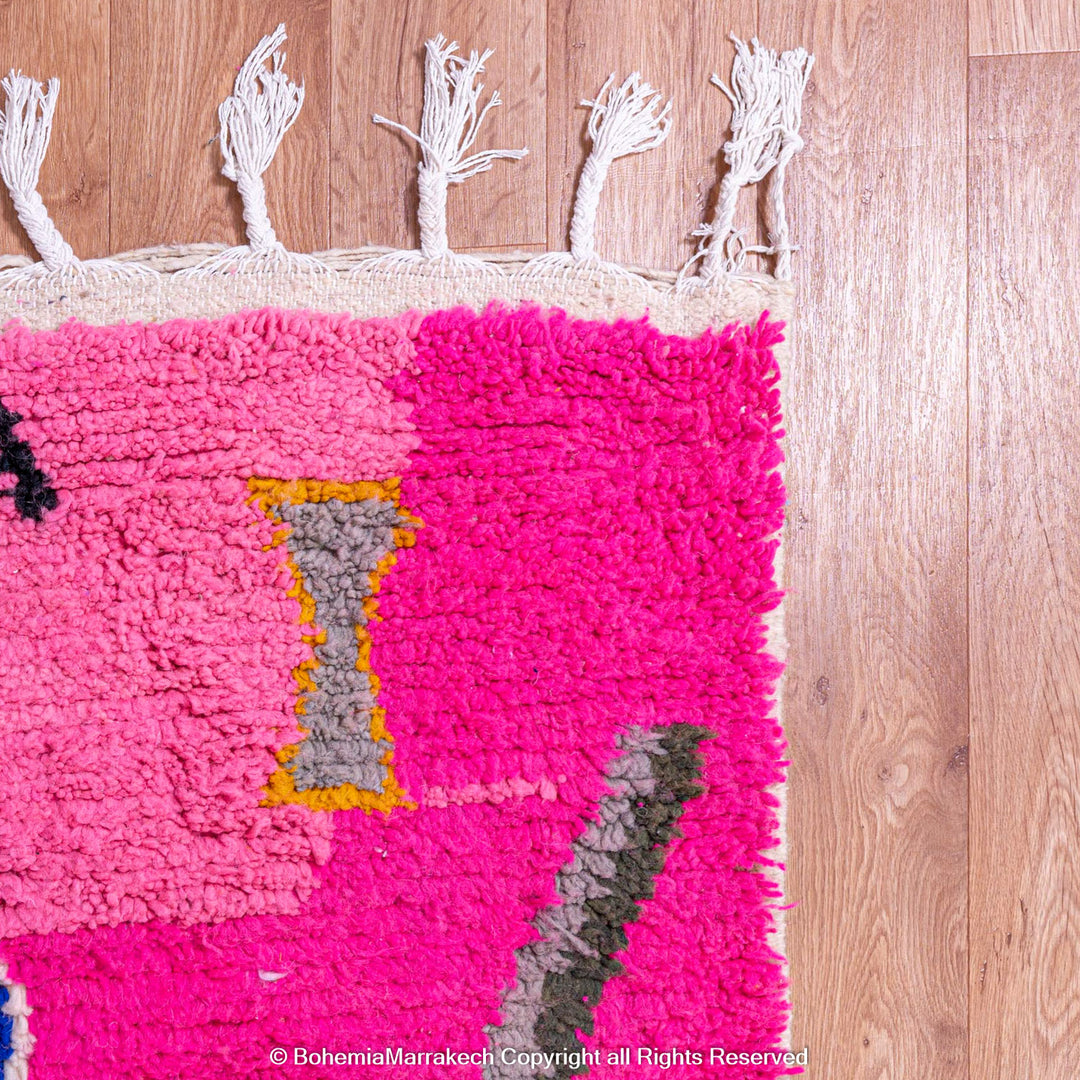 Handmade pink Moroccan rug with multicolor tribal geometric motifs, crafted in wool by Berber artisans