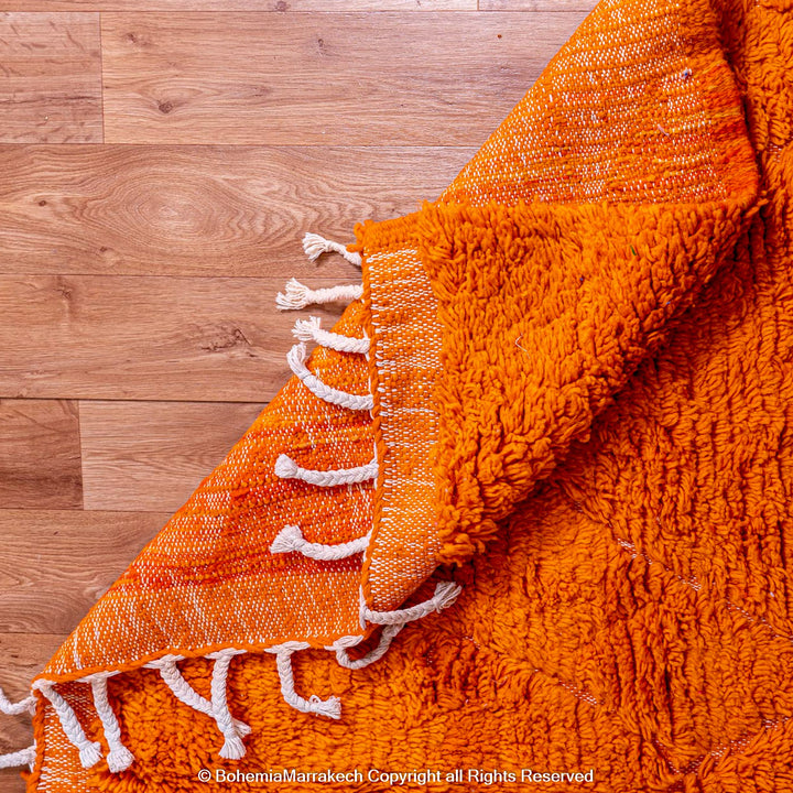 Handmade orange Moroccan rug with subtle diamond pattern and soft wool texture