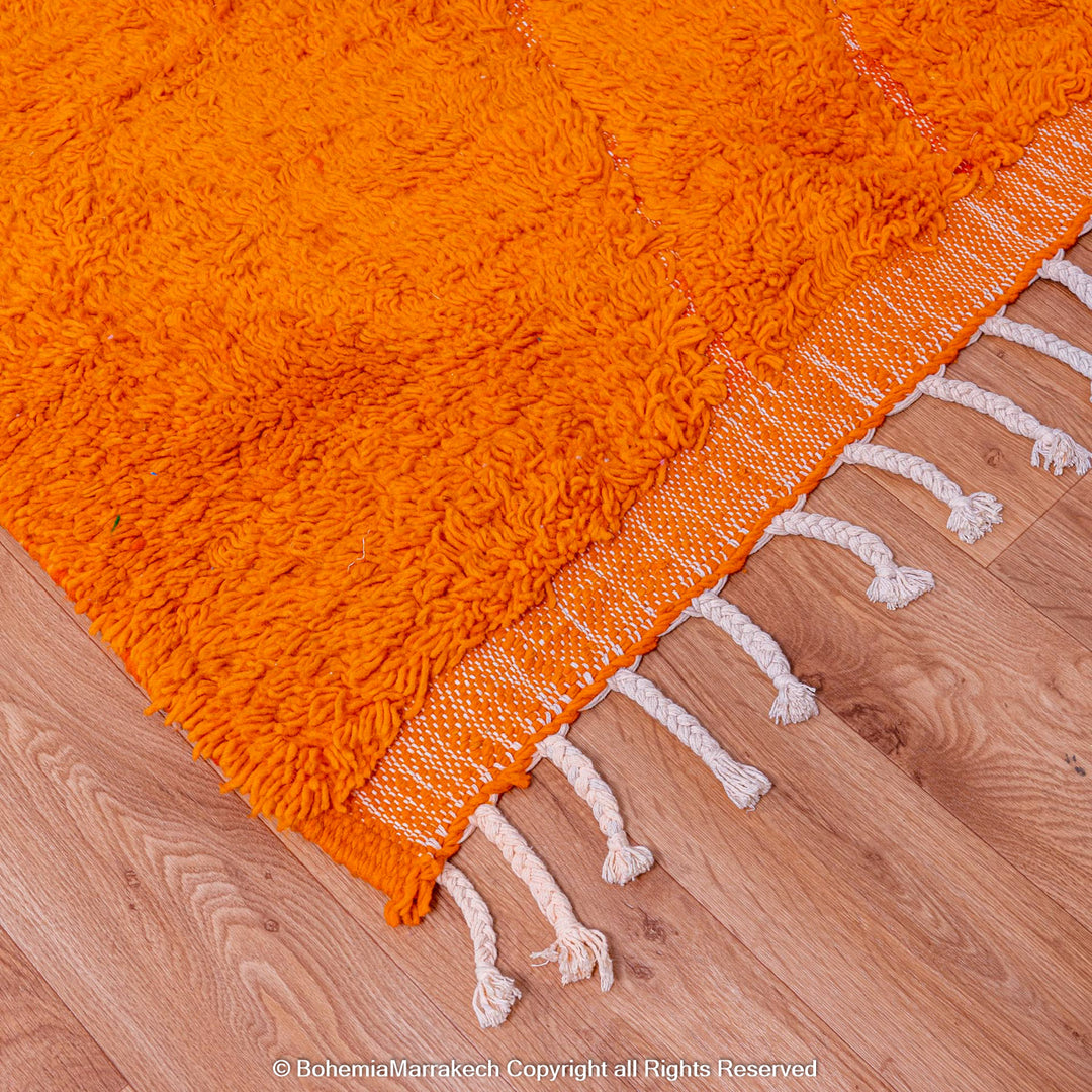 Handmade orange Moroccan rug with subtle diamond pattern and soft wool texture
