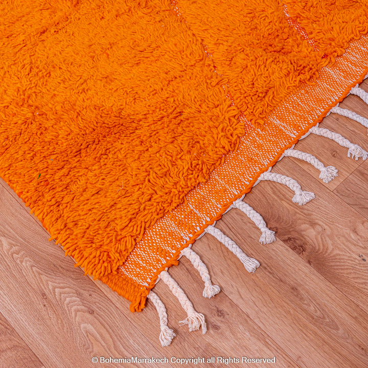 Handmade orange Moroccan rug with subtle diamond pattern and soft wool texture