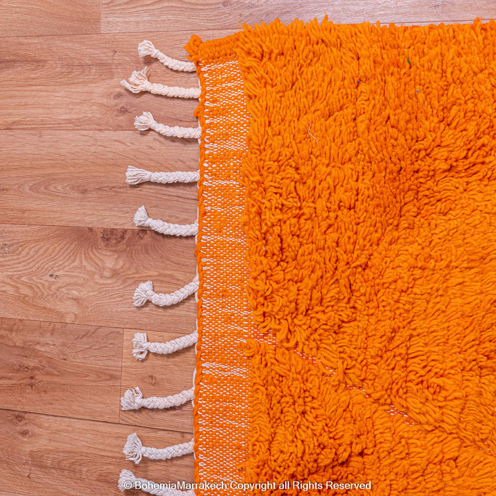 Handmade orange Moroccan rug with subtle diamond pattern and soft wool texture