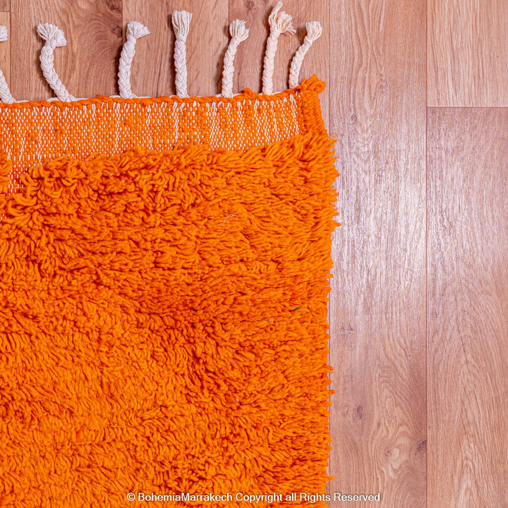 Handmade orange Moroccan rug with subtle diamond pattern and soft wool texture