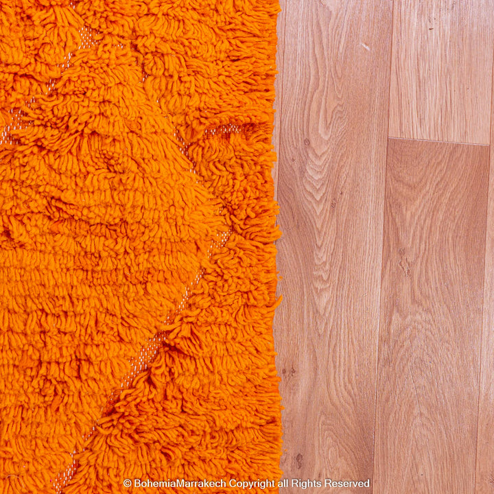 Handmade orange Moroccan rug with subtle diamond pattern and soft wool texture