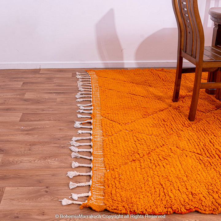 Handmade orange Moroccan rug with subtle diamond pattern and soft wool texture