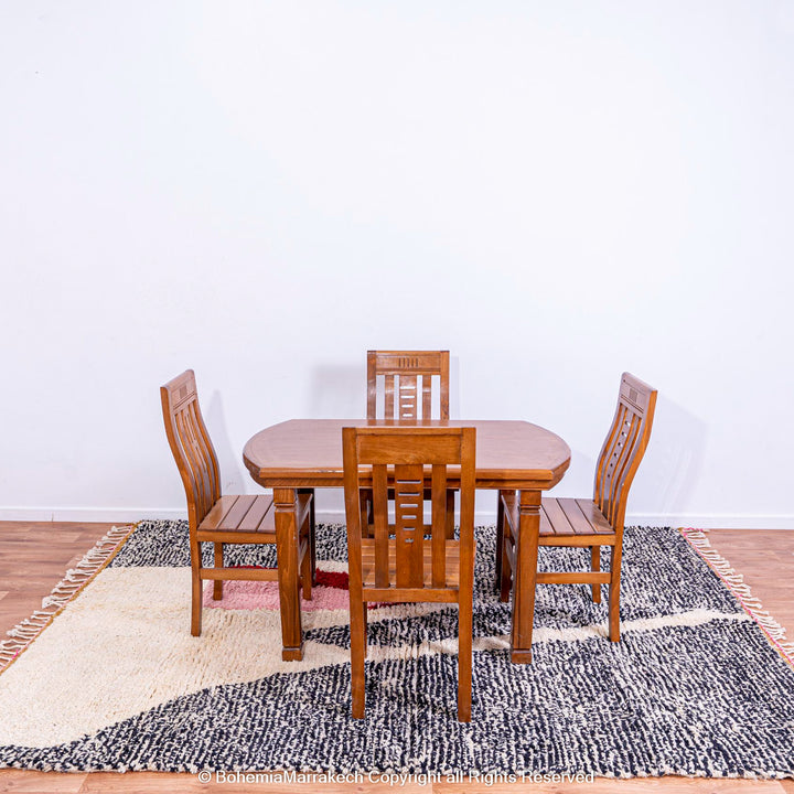 Dining table set on abstract grey Moroccan rug with artistic design in cream, red, and blush pink, handmade from wool.