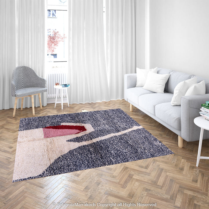 Abstract Grey Moroccan Rug in modern living room with grey and black textured base, featuring cream, red, and pink abstract design.