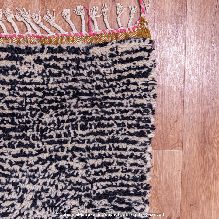 Handmade wool Moroccan Berber rug with black and white pattern, showcasing traditional craftsmanship and texture.