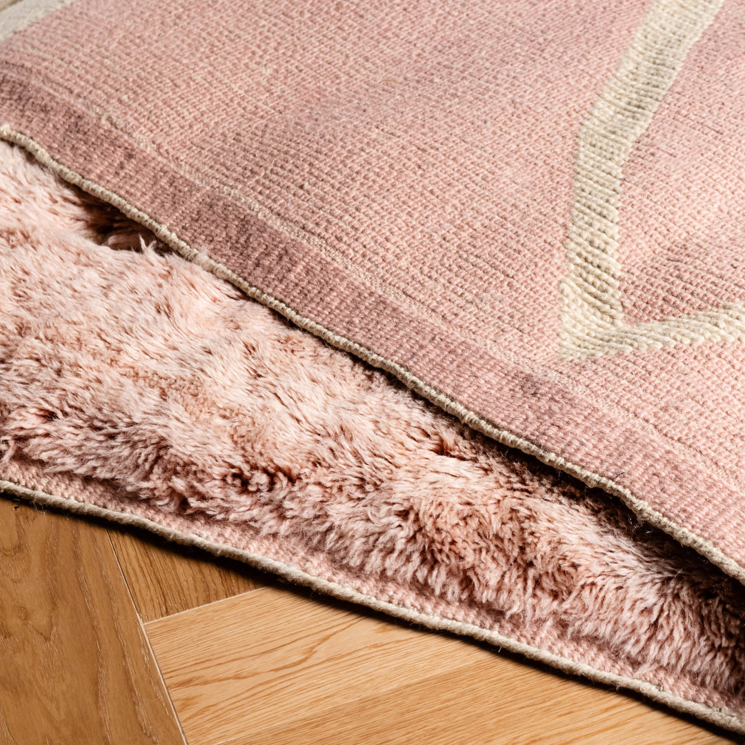 Custom pink Moroccan rug with abstract triangle motif and plush wool texture; ideal for modern interiors; traditional craftsmanship.