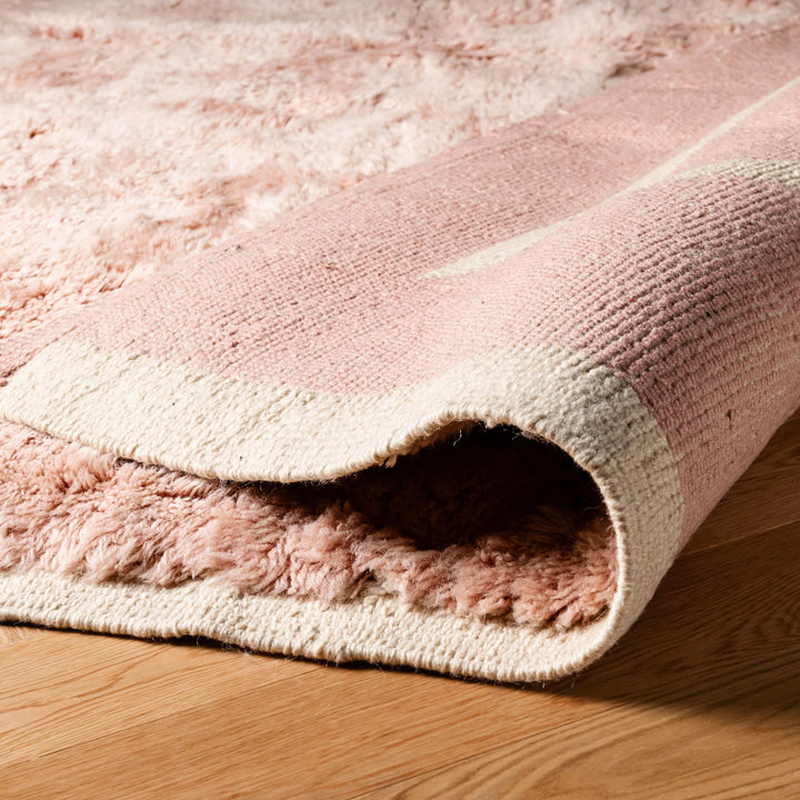 Custom pink Moroccan rug with abstract triangle design in blush wool, showcasing traditional craftsmanship ideal for modern spaces.