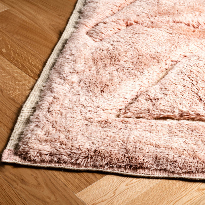 Custom pink Moroccan rug with abstract triangle design, plush wool texture, ideal for minimalist or boho interiors.