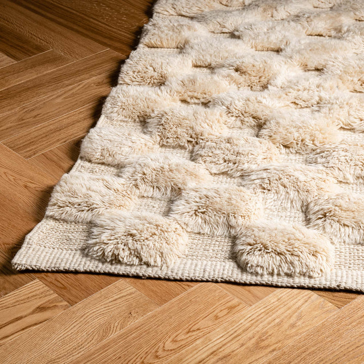 Handwoven wool Moroccan rug with raised circular texture, ideal for cozy interiors. Perfect for contemporary or boho style rooms.