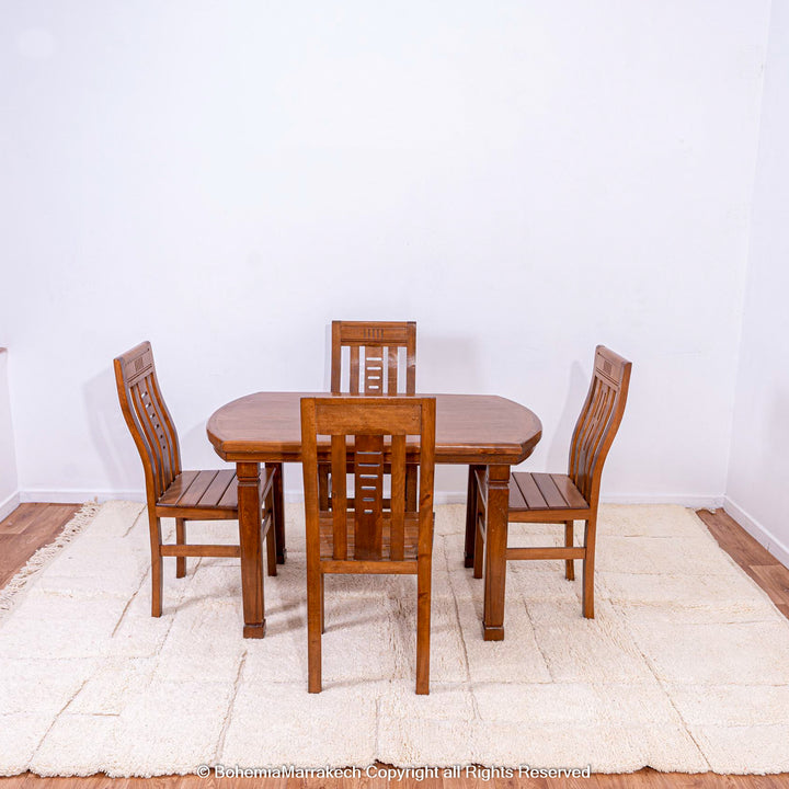 Wooden dining table set on an off-white Moroccan rug with minimalist Berber design, showcasing elegant craftsmanship.