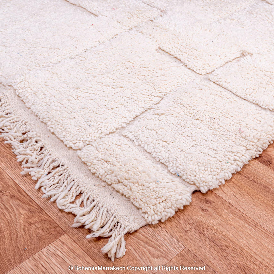 Minimalist off-white Moroccan wool rug with Berber geometric patterns, handmade from natural wool, perfect for modern interiors.