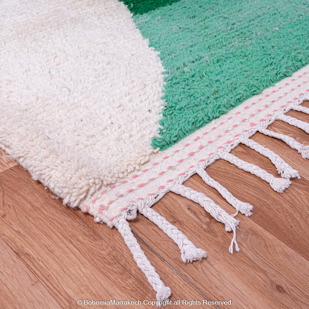 Close-up of a Pink Green Modern Moroccan Berber Wool Rug with fringe, showcasing abstract design and vibrant colors.