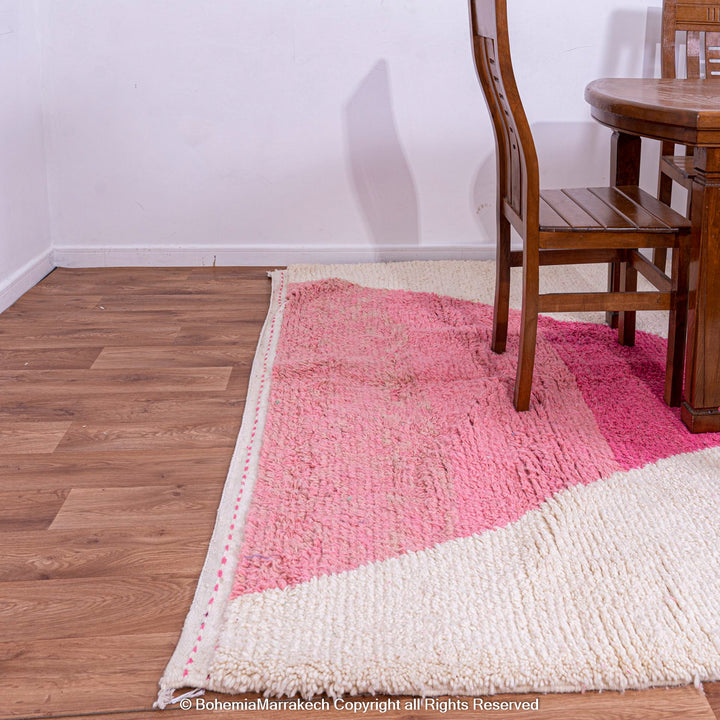 Modern Moroccan pink and green wool berber rug in dining area floor, vibrant abstract design, handcrafted in Atlas Mountains.