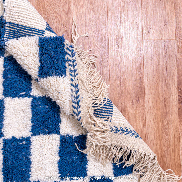 Blue and white checkered Moroccan wool rug with plush shag texture