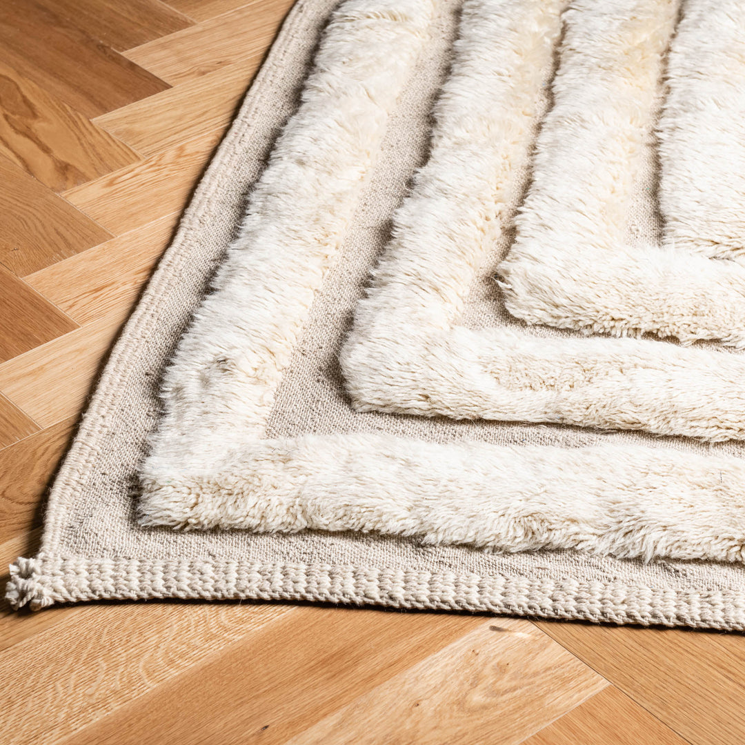 Close-up of Geometric Beni Mrirt Moroccan wool rug with cream linear patterns and rich texture.