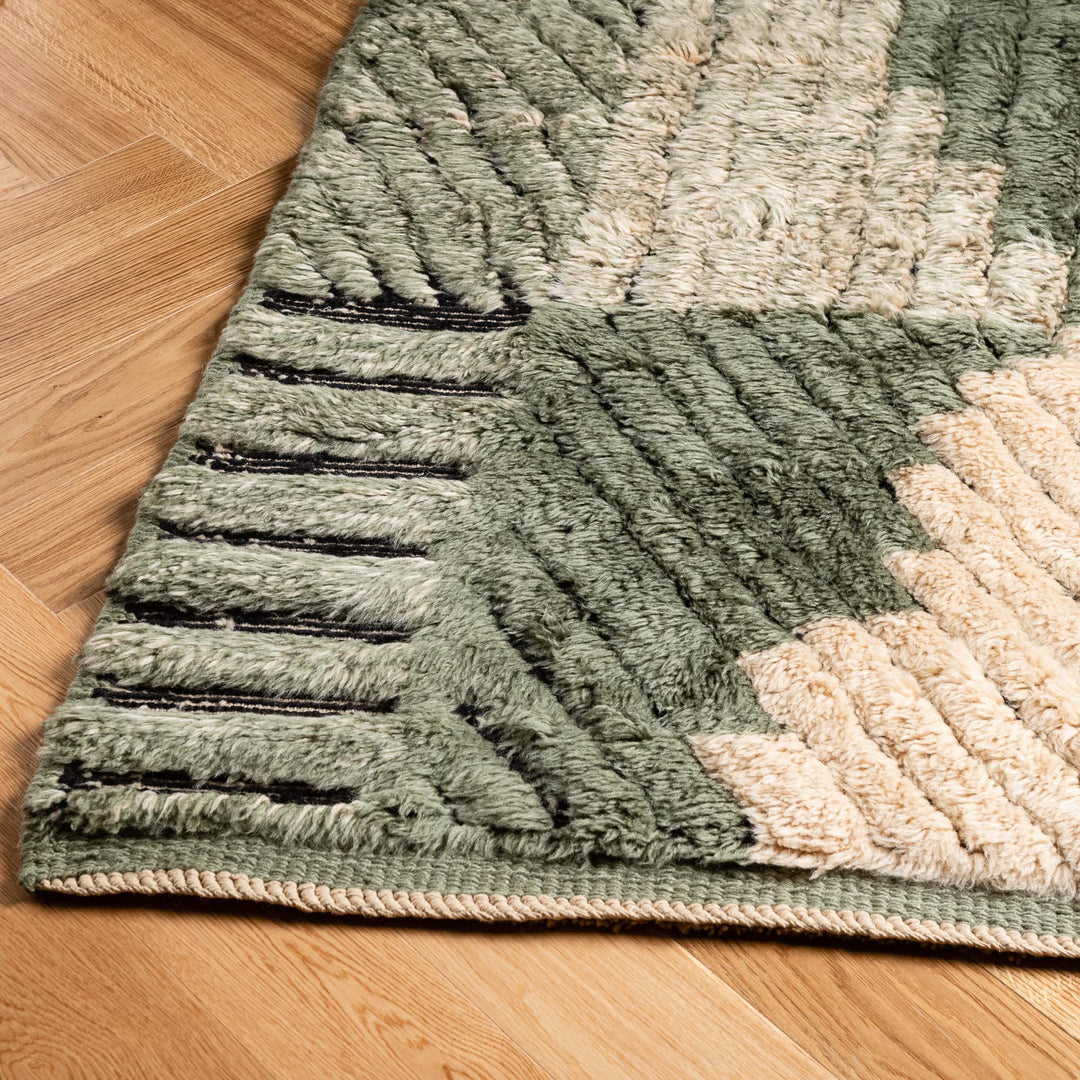 Close-up of handmade Geometric Moroccan Wool Rug with earthy greens and creams, showcasing modern patchwork and traditional Berber design.