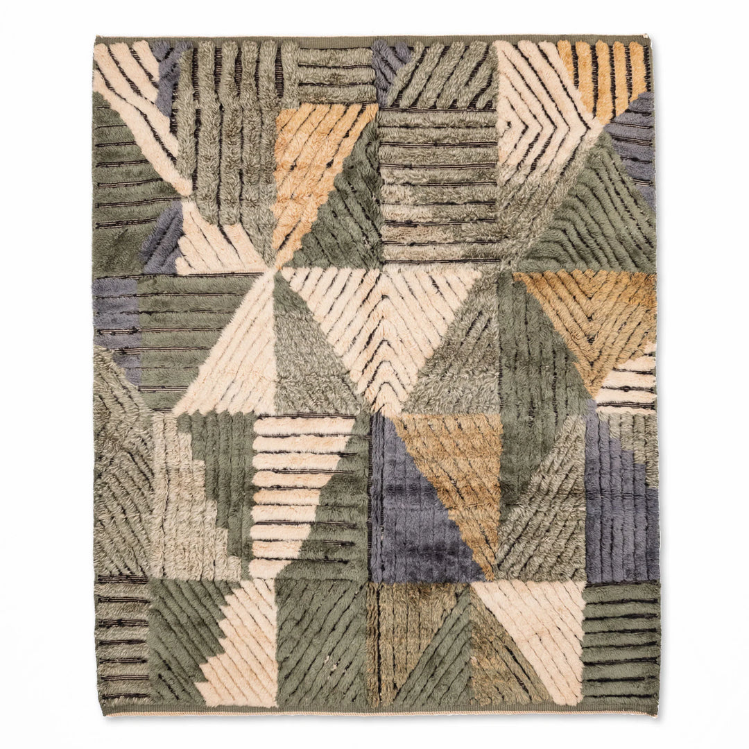 Geometric Moroccan wool rug with handmade patchwork in earthy greens, creams, ochres, and blues; traditional Berber style.