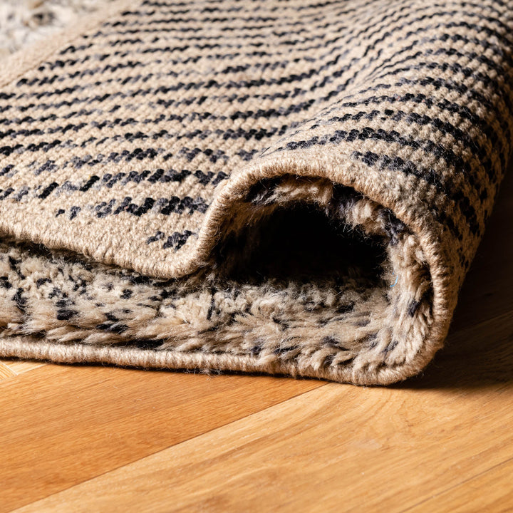 Close-up of handmade Beni Mrirt wool rug showcasing thick, plush texture and traditional Moroccan design on wooden floor.