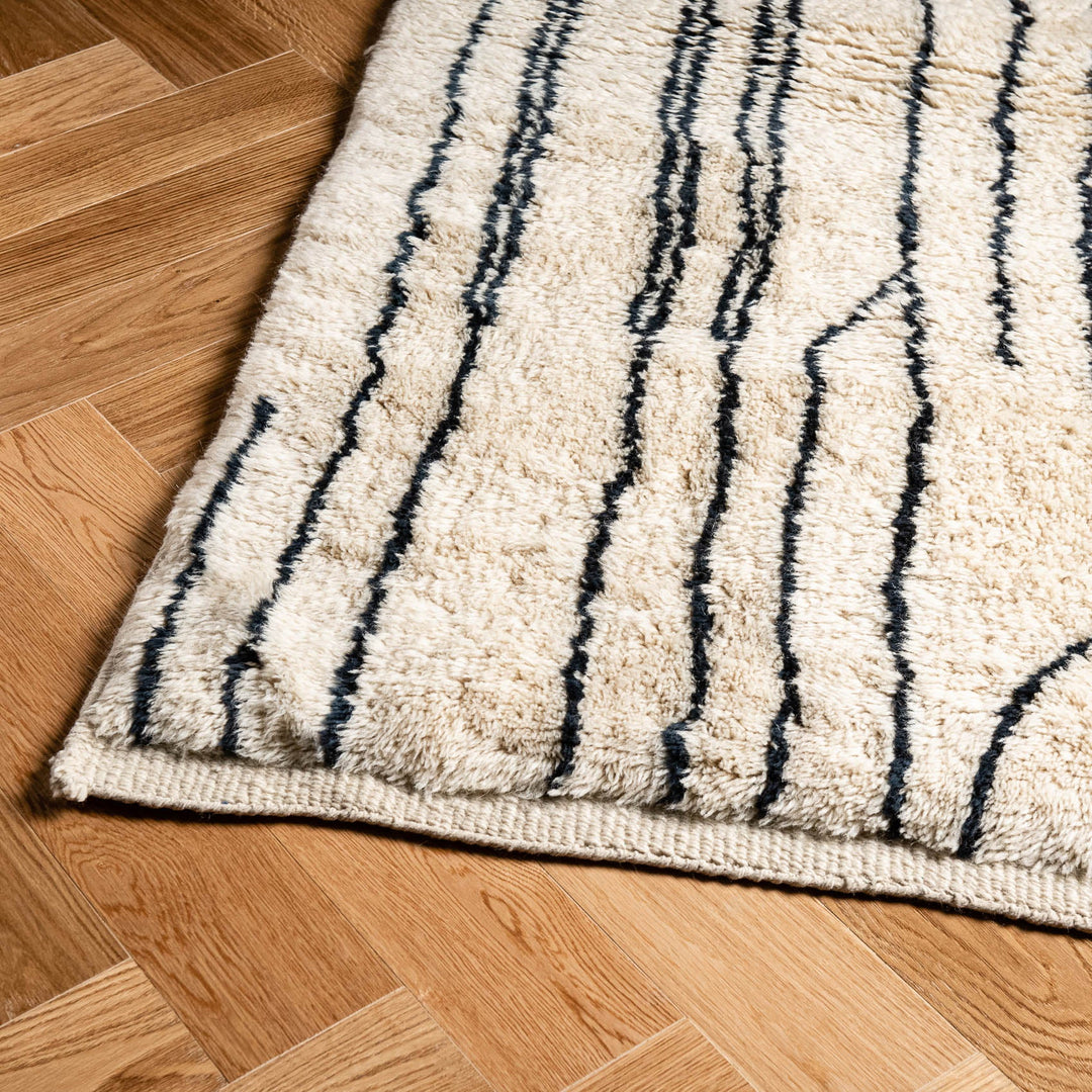 Handmade Moroccan wool rug with abstract linear design on wooden floor