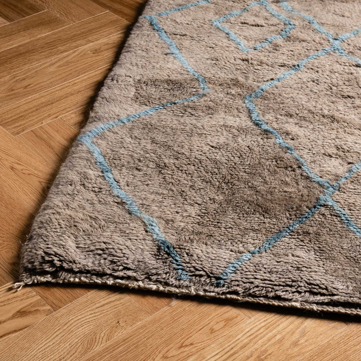 Handmade Moroccan Berber rug with traditional diamond pattern in blue, ideal for rustic and contemporary interiors.