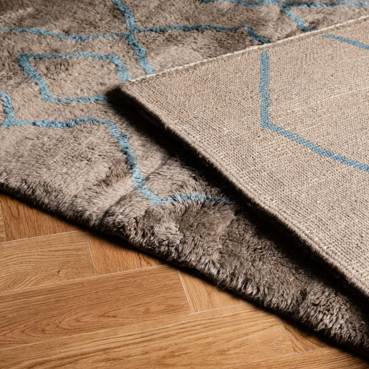 Handmade Moroccan rug with blue diamond pattern, showcasing luxurious texture. Ideal for contemporary interiors.