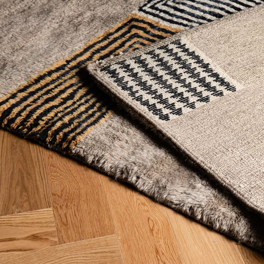 Handmade Moroccan wool rug with geometric line pattern on hardwood floor. Moroccan Berber style, perfect for modern interiors.