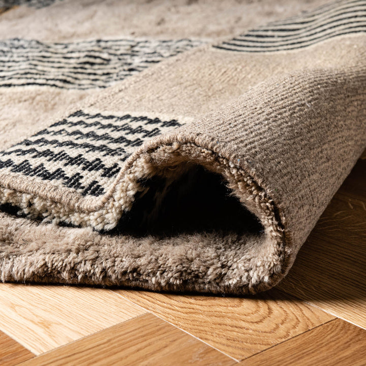 Close-up of a handmade Moroccan wool rug with a geometric line pattern, ideal as a traditional Moroccan carpet or Berber rug.