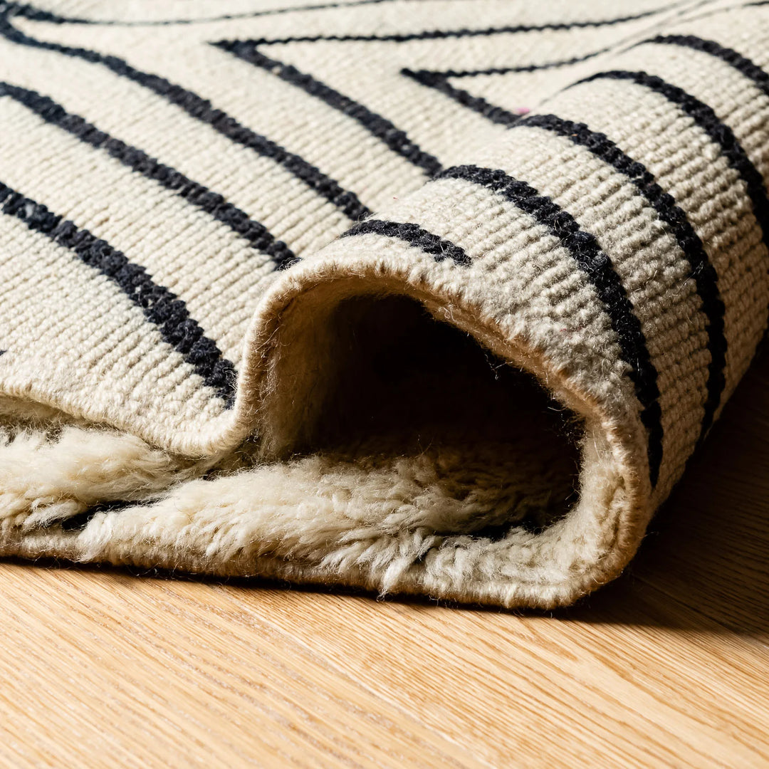 Close-up of a handwoven black and white Moroccan Berber runner rug, showcasing detailed natural wool texture and traditional patterns.