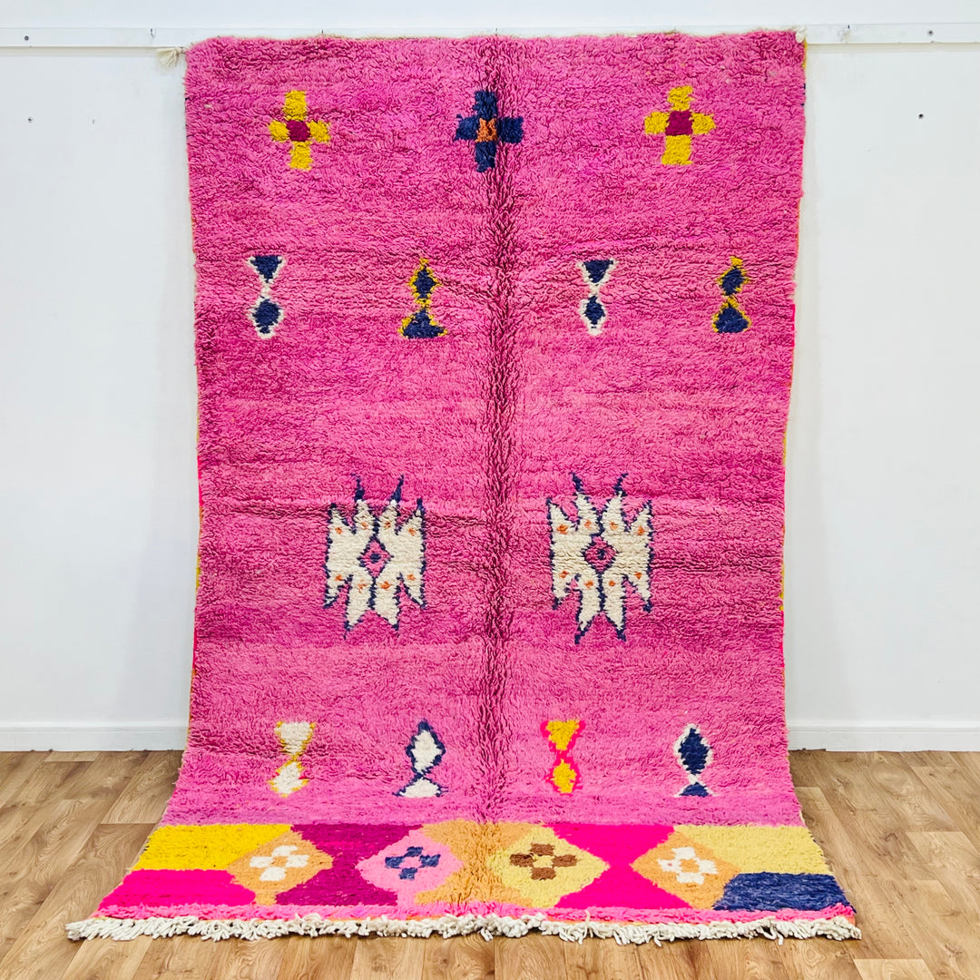 Vintage pink Moroccan Berber rug with traditional tribal symbols, handwoven wool, adds warmth and color to any space.