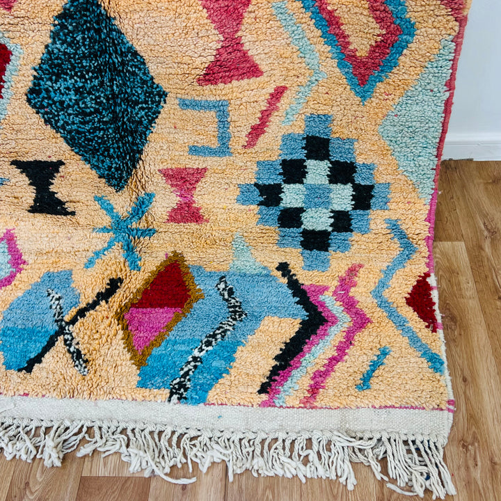 Vintage Moroccan Berber rug with pink and turquoise diamond and tribal motifs, handcrafted from wool. Ideal for modern boho interiors.