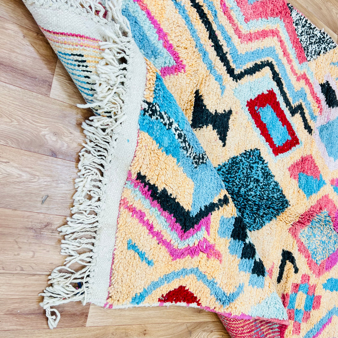 Vintage Moroccan Berber rug with pink, turquoise, and black diamond patterns, handwoven wool, perfect for modern boho interiors.