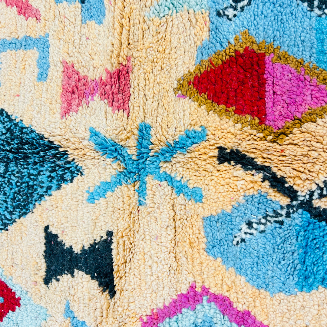 Vintage Moroccan Berber rug in pink, turquoise, yellow, and black with diamond and tribal motifs, wool texture